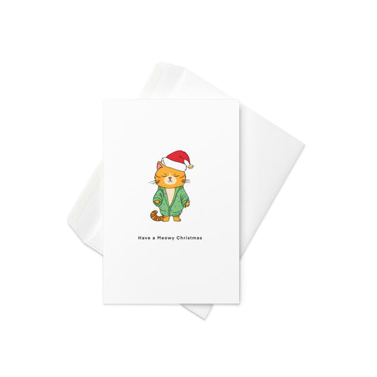 Christmas Card, have a meowy Christmas, at themed Christmas card, cute Christmas card. A little cat in a dressing gown and wearing a cute Christmas/Santa hat, text reads have a meowy Christmas. pun card. blank inside.